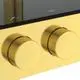 Duschsystem mit Brausethermostat in gebürstetem Gold, bestehend aus zwei runden Bedienknöpfen und einer schwarzen Oberfläche, hergestellt von Ideal Standard.